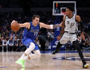 Luka Doncic, left, guarded by Dejounte Murray, right.